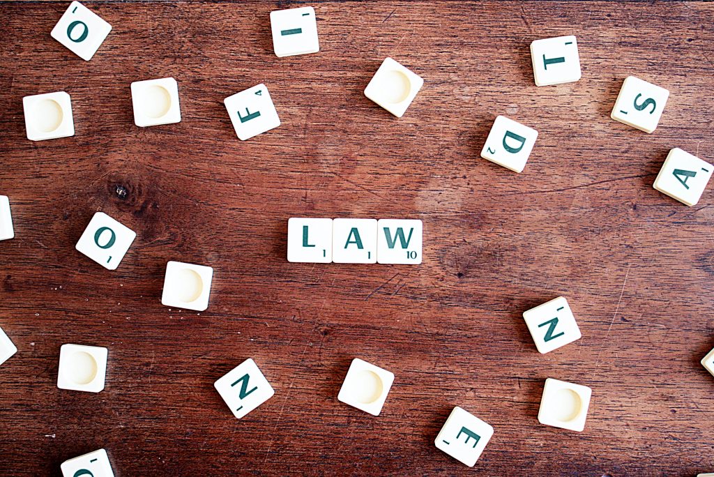 Scrabble tiles spelling law surrounded by other letter tiles